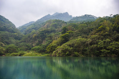 Scenic view of lake and mountains against sky