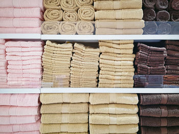 Stacked soft fluffy towels on shelves at clothing store