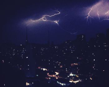 Aerial view of illuminated cityscape against sky at night