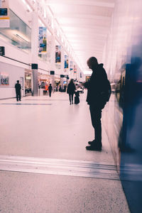 People walking on illuminated railroad tracks in city