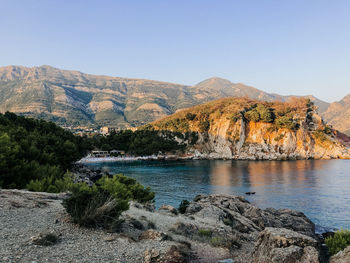 Scenic view of lake and mountains against clear sky