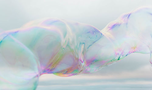 Close-up of bubbles in mid-air against sky