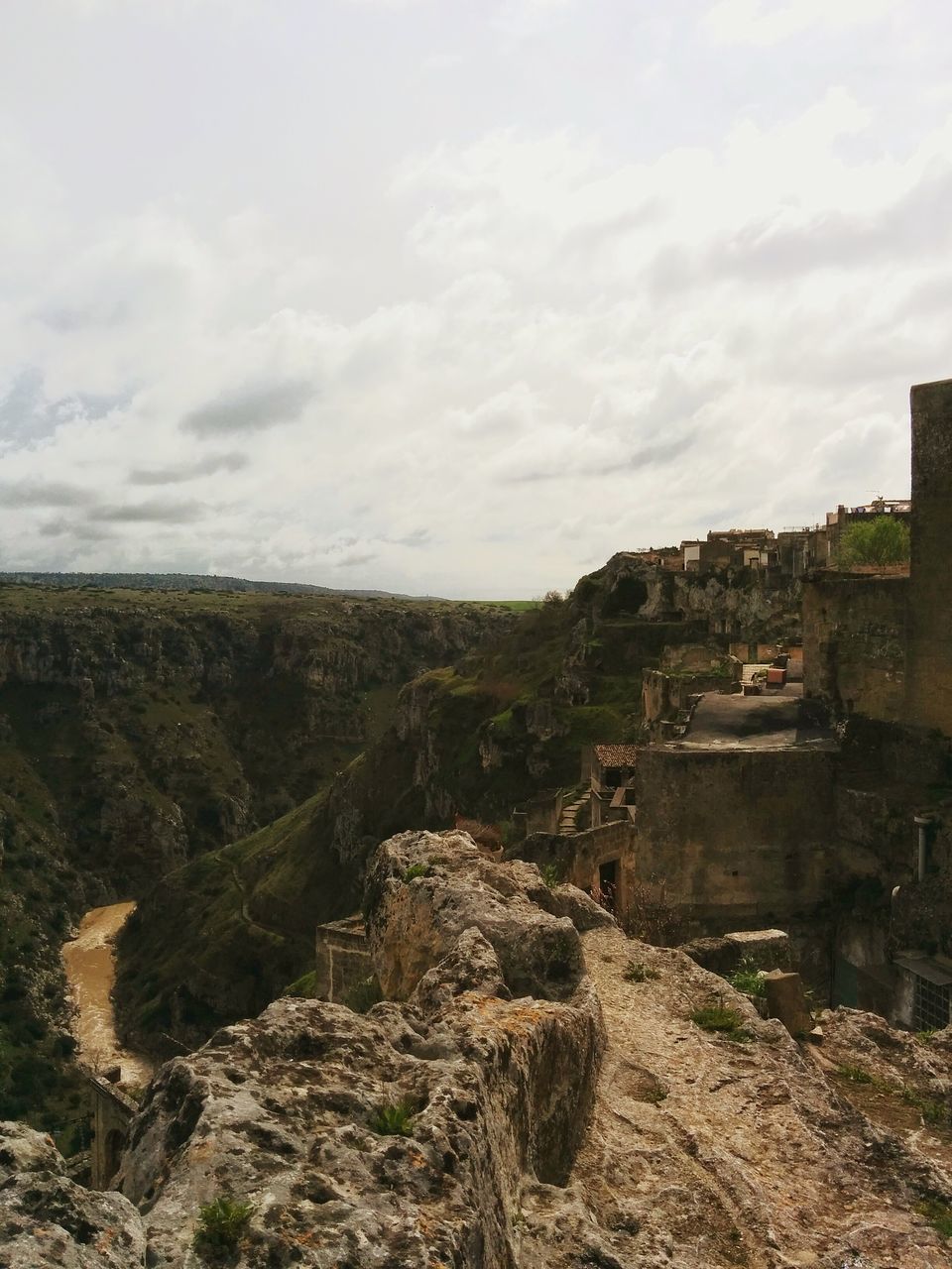 VIEW OF LANDSCAPE WITH BUILDINGS AGAINST CLOUDY SKY