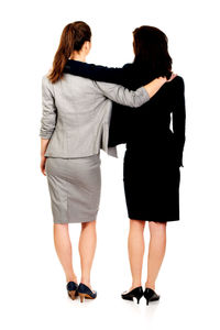 Rear view of women standing against white background