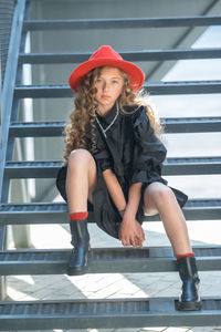 Portrait of woman wearing hat against staircase