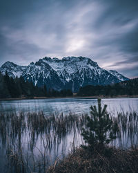 Scenic view of lake and snowcapped mountains against sky