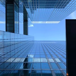 Low angle view of modern glass building against sky