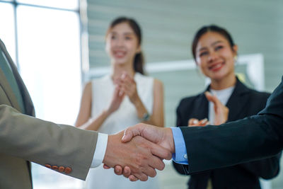 Business colleagues shaking hands in office