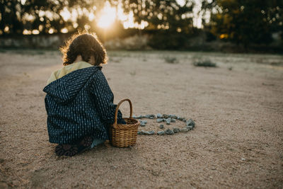 Rear view girl playing with rocks