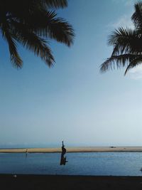 Man fishing in sea against clear sky