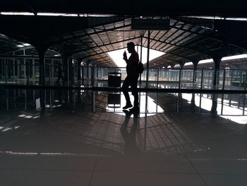 Silhouette man walking on railroad station platform