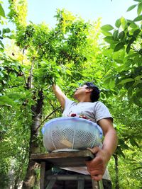 Side view of woman standing by trees