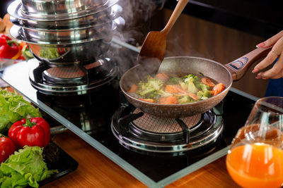 Cropped hand of person preparing food on table