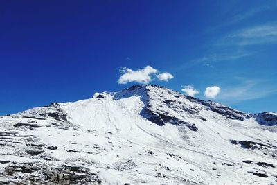 Scenic view of snowcapped mountains against blue sky