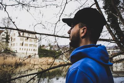 Man by bare tree during winter