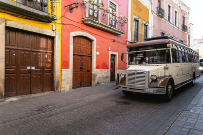 Car on street by buildings in city