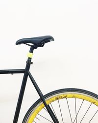 Low angle view of woman riding bicycle against clear sky