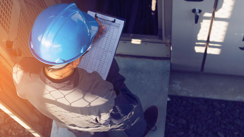 Male engineer writing in paper at industry