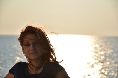 Portrait of woman against sea during sunset
