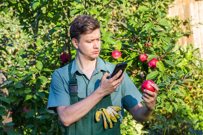 Portrait of young man holding plant