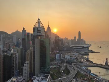 Aerial view of buildings in city during sunset