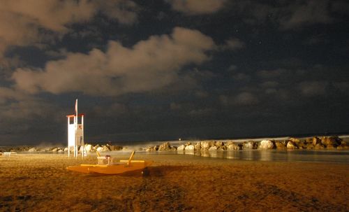 Scenic view of beach against sky at dusk