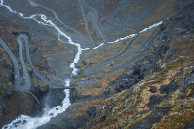 Trollstigen mountain road crossing river in norway. bird's eye view aerial. panoramic.