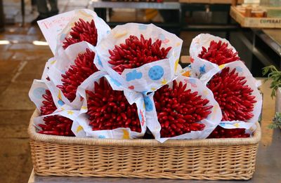 Close-up of red flowers in basket at market stall