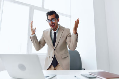 Portrait of businessman using laptop at office