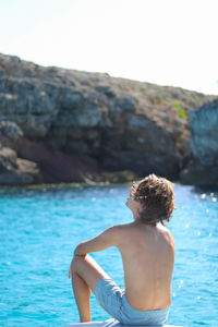 Back portrait of man on luxury yacht deck relaxing on summer vacation trip