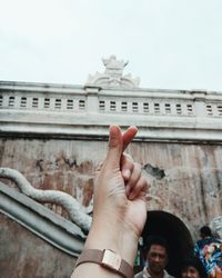 Low angle view of baby hands against building