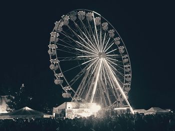 Low angle view of illuminated ferris wheel against sky at night