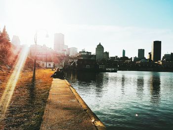 Sunset over river with buildings in background