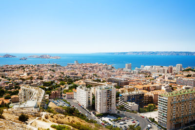 High angle view of townscape by sea against clear sky