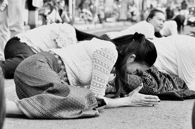 Women kneeling and praying on street during performance