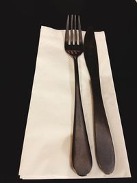 Close-up of fork on table against black background