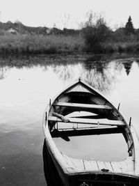 Boat moored in lake against sky