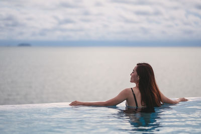 Rear view of woman swimming in sea