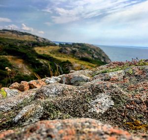Scenic view of rocks on sea against sky