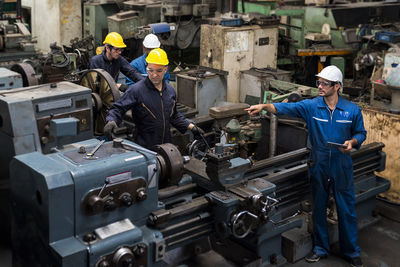 Technicians machines. group of factory workers using machine equipment in factory workshop.
