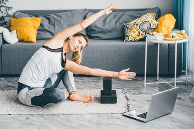Low section of woman doing yoga at home
