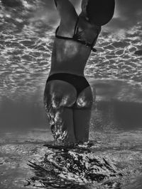 Low section of woman in bikini swimming in sea
