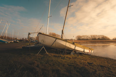 Sailboats moored on lake against sky