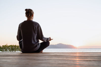 Health and wellness. young healthy woman practicing yoga meditating on the beach at sunset