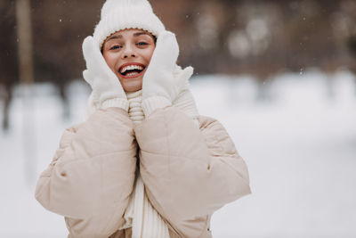 Portrait of young woman standing on snow