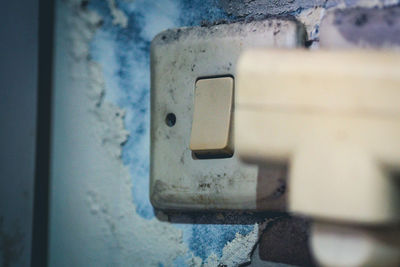 Close-up of old electric light on wall