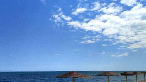 Scenic view of beach umbrellas  against de-a and sky