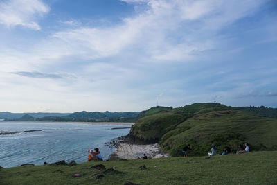 People at beach against sky