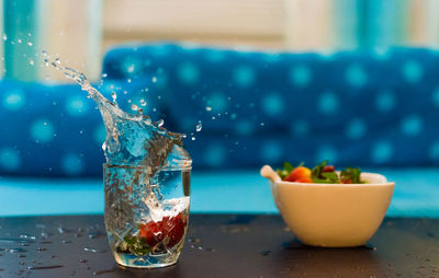 Close-up of water splashing in glass on table