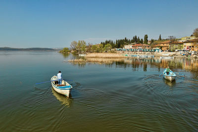 High angle view of boats moored in lake against clear sky